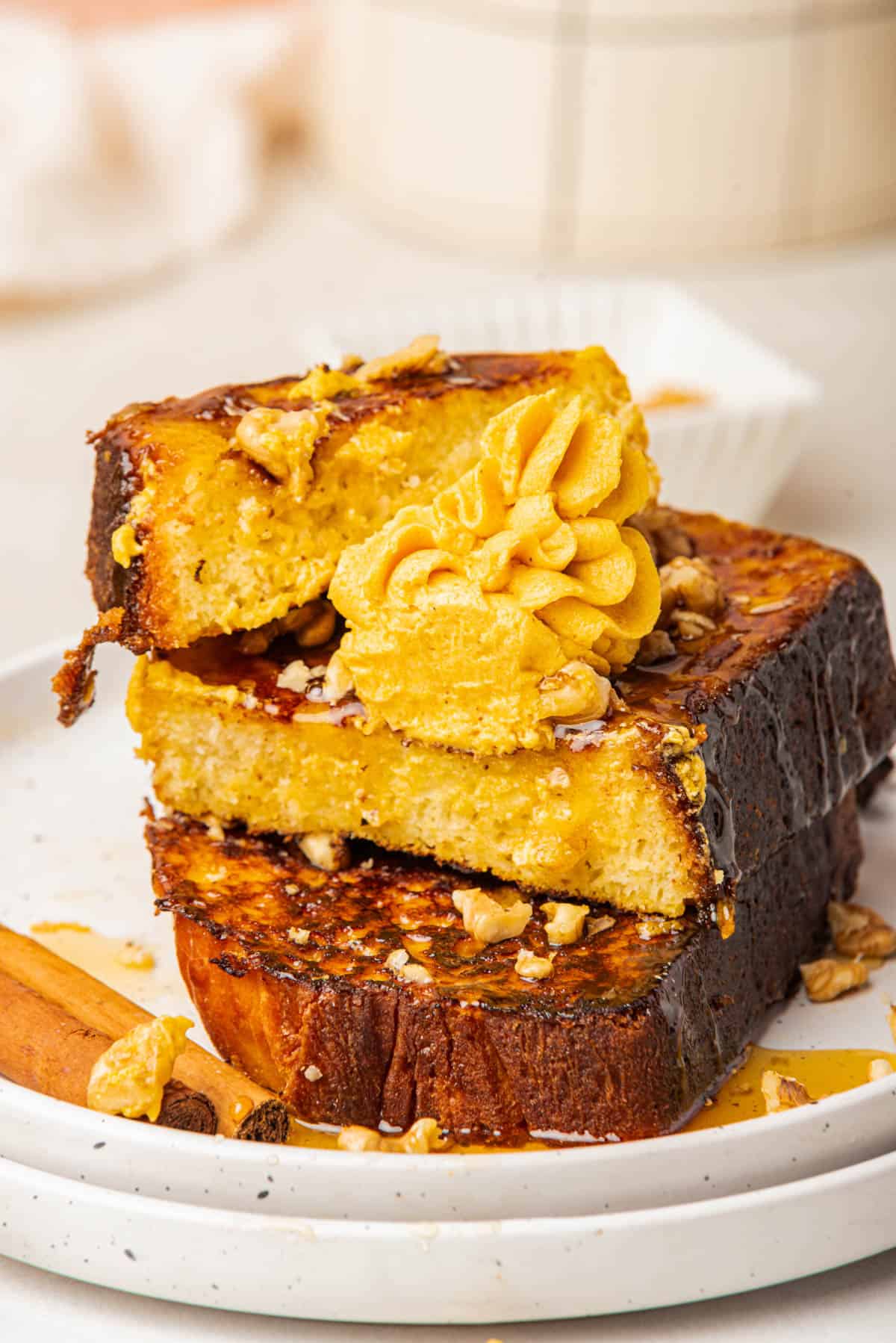 Slices of pumpkin french toast with pumpkin butter and syrup.