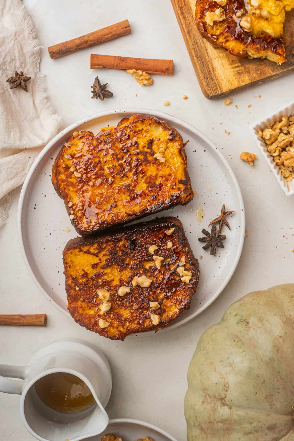 An overhead image of two slices of pumpkin french toast on a plate.