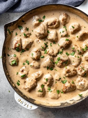 An overhead image of a pan of swedish meatballs in creamy sauce.