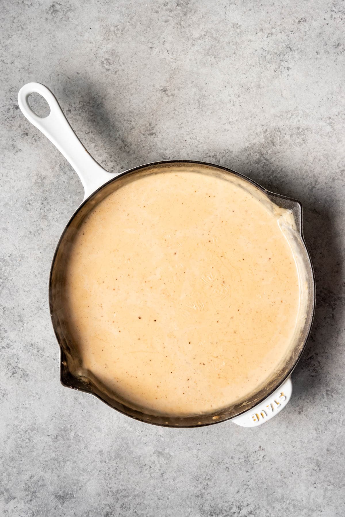 A creamy gravy in a large pan.