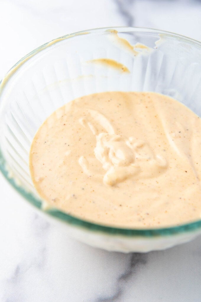 A batch of homemade yum yum sauce in a glass mixing bowl.