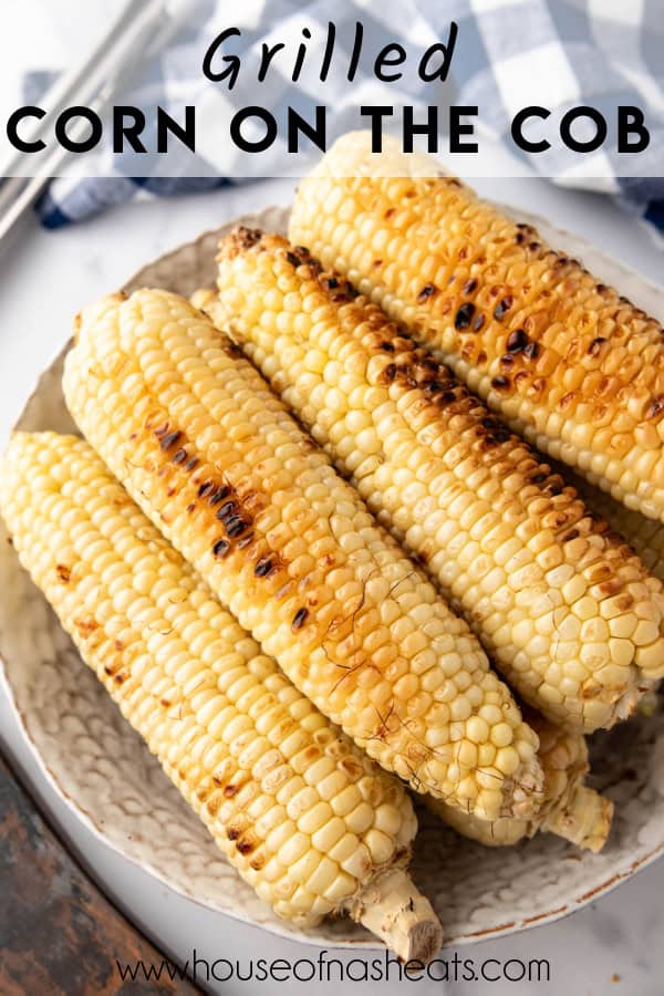 Grilled corn on the cob on a serving platter with text overlay.