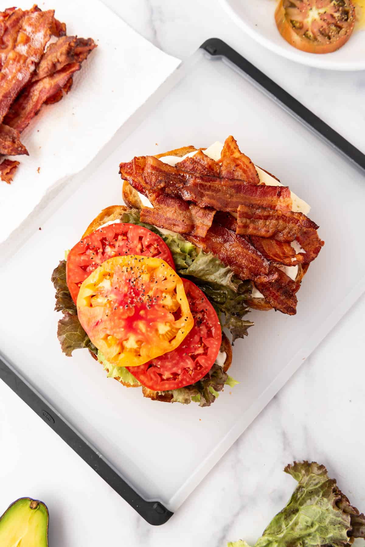 Assembling a BLT on a cutting board.