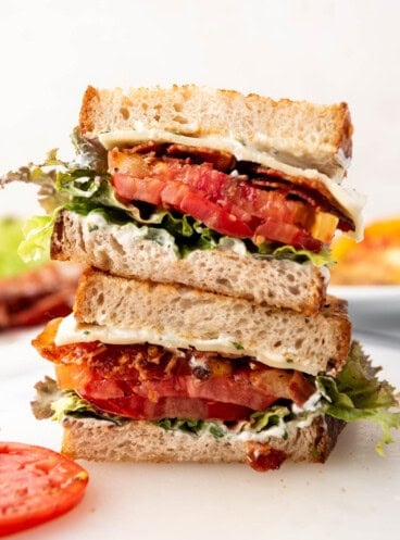 A BLT sandwich that has been sliced in half and stacked.