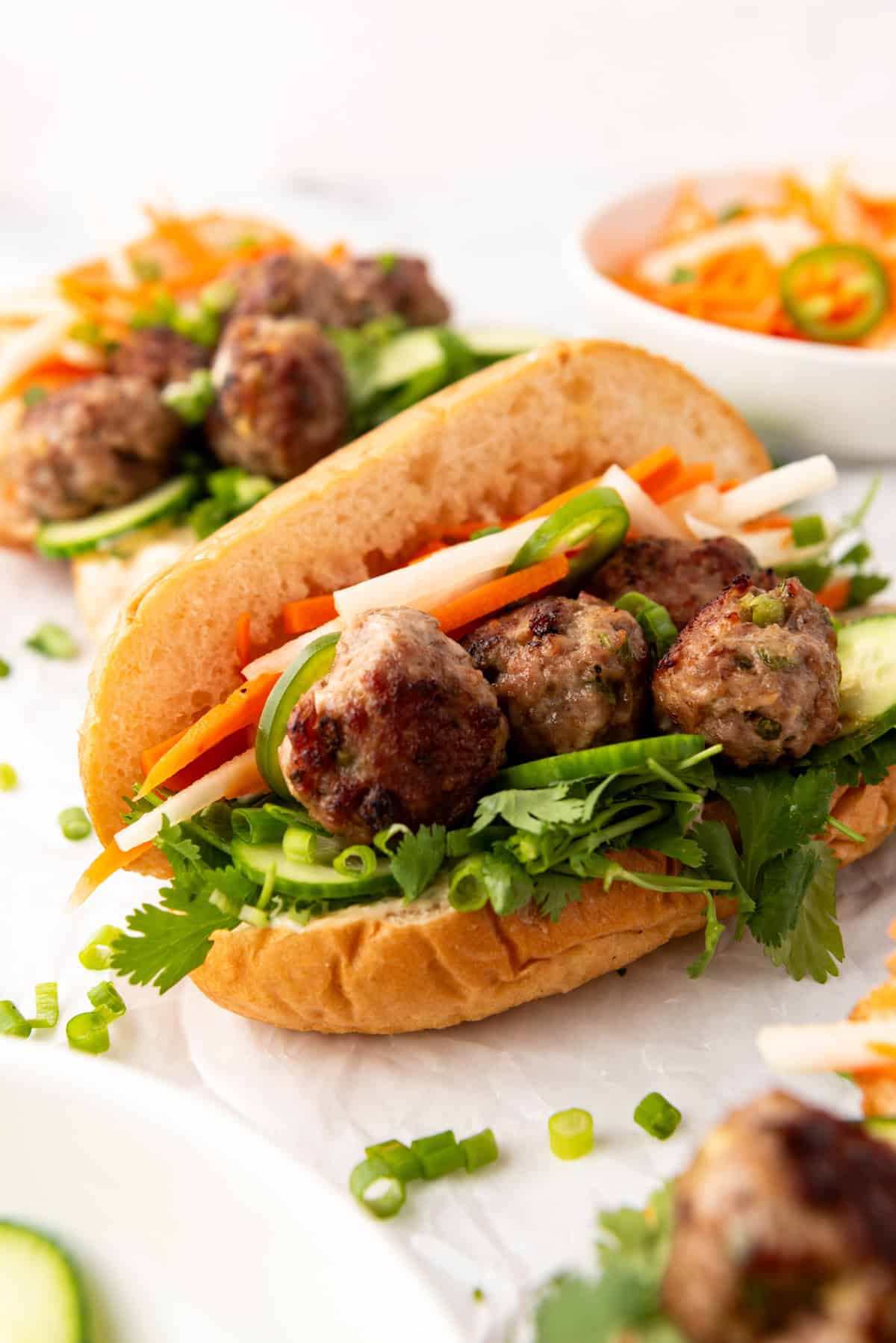 An image of Vietnamese-inspired meatballs on a banh mi sandwich.