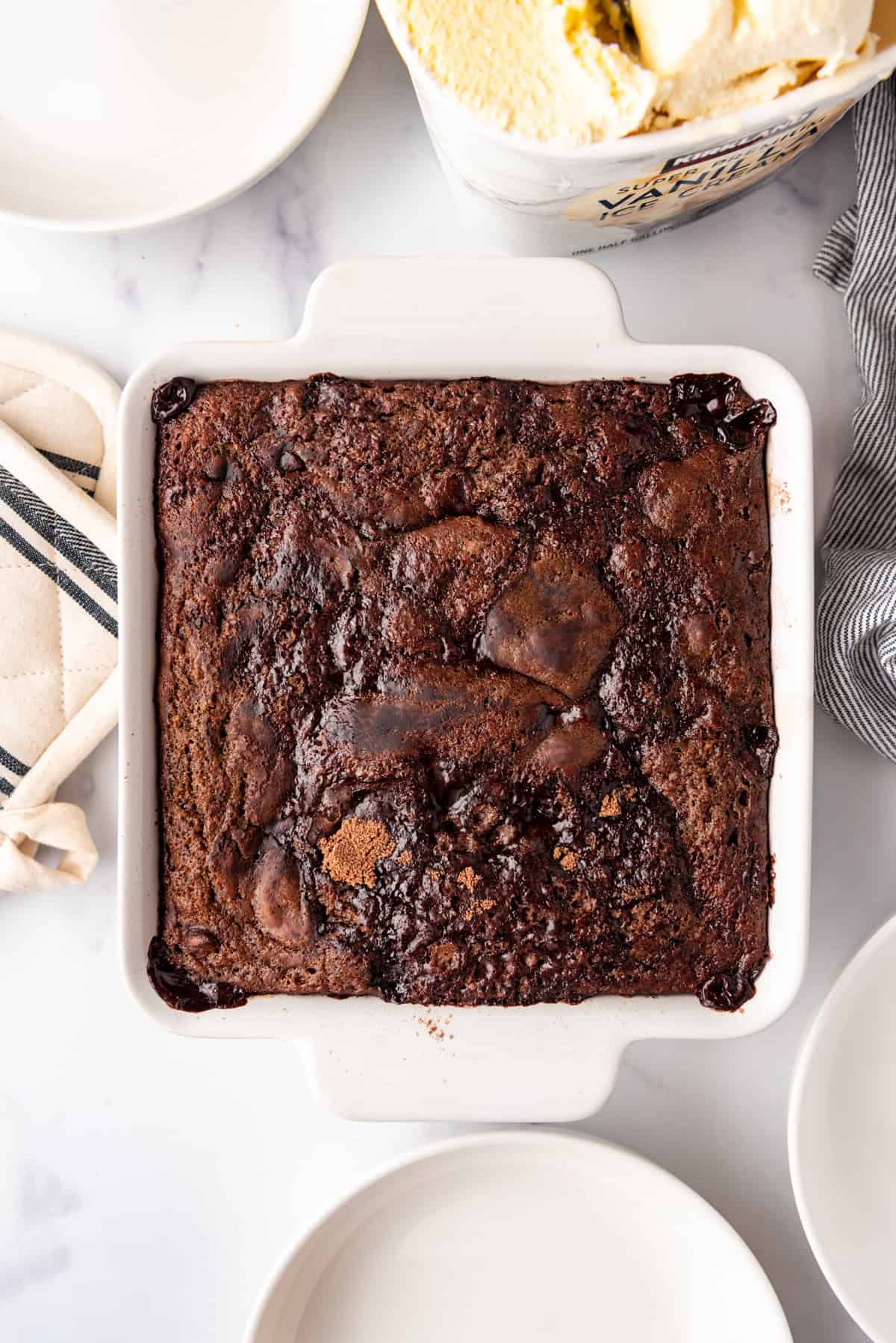 A baked chocolate cobbler in a white dish.