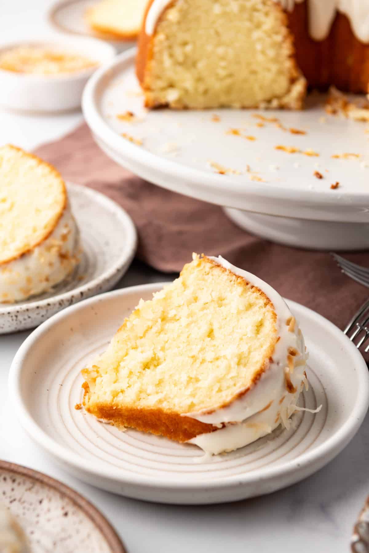 A slice of coconut bundt cake on a plate.