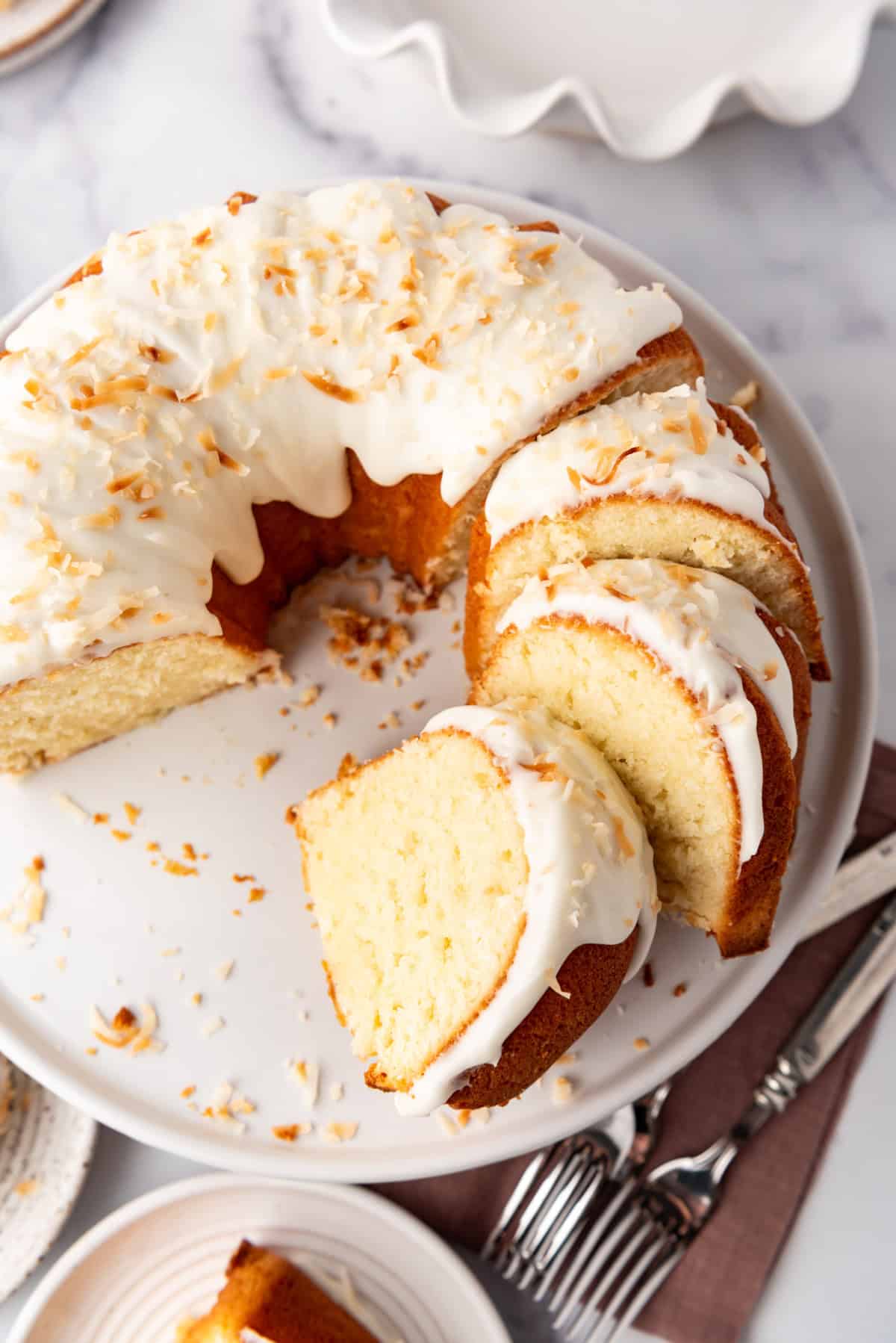 A sliced coconut bundt cake on a white plate.