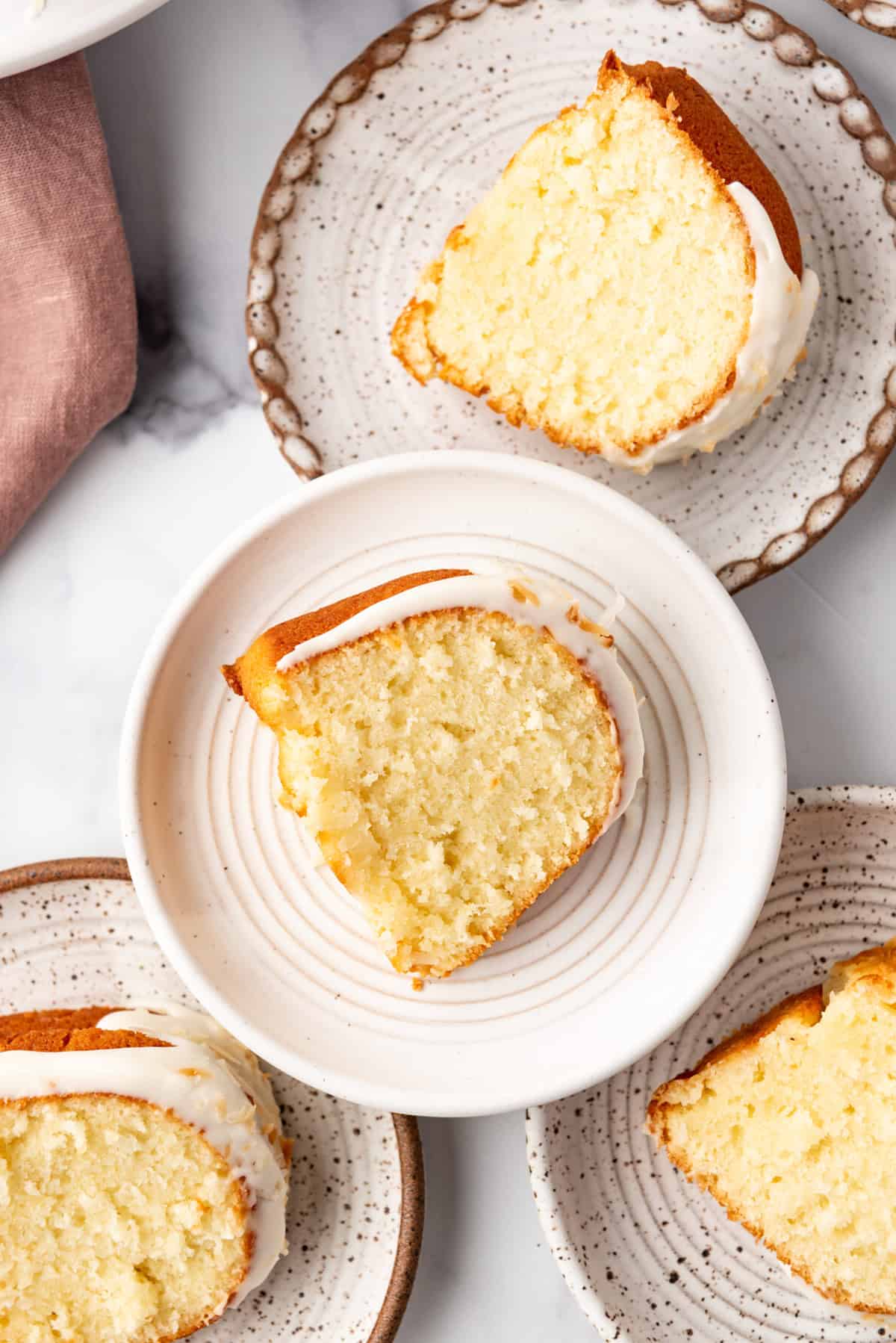 An overhead image of plates of coconut bundt cake.