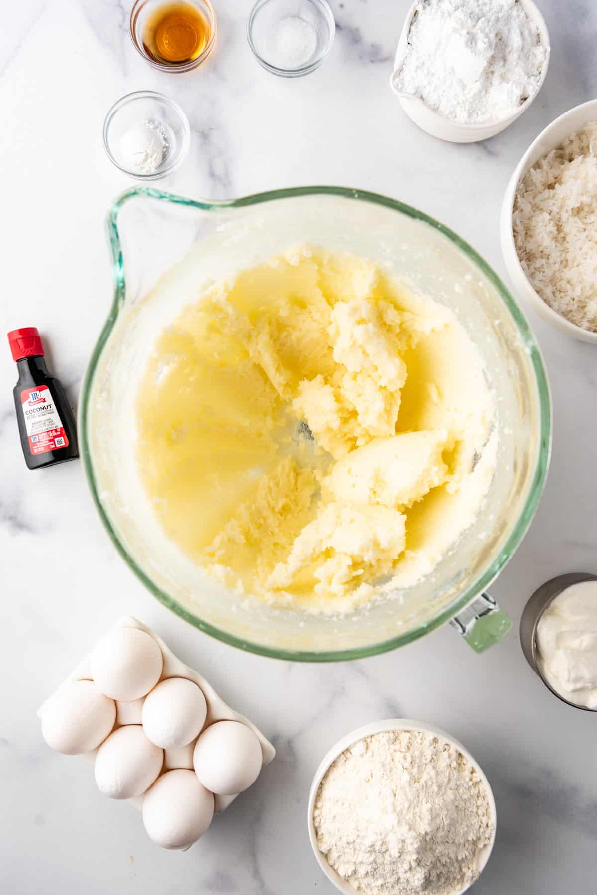 Creaming butter, sugar, and sour cream together in a large glass mixing bowl.