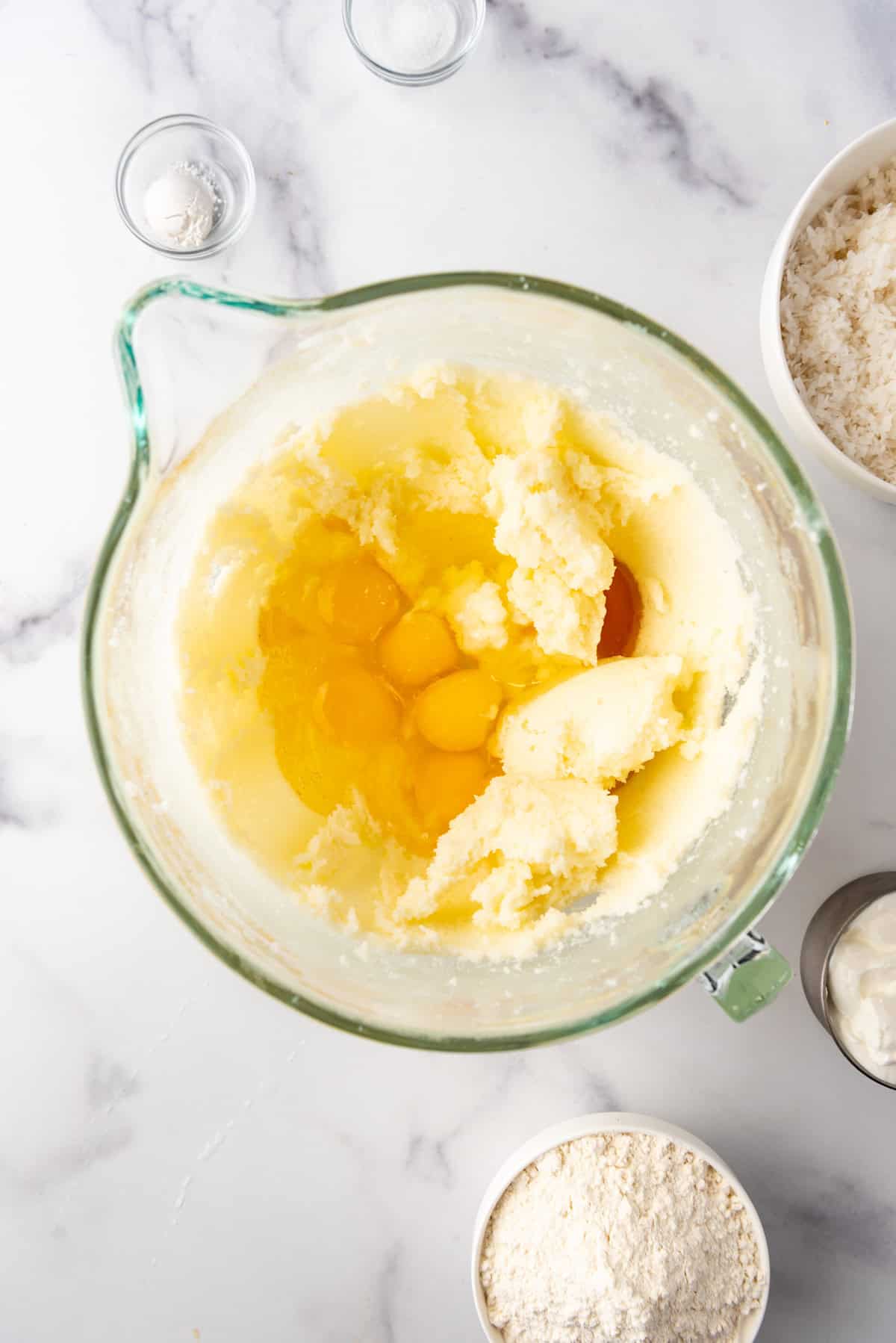 Adding eggs to coconut bundt cake batter.