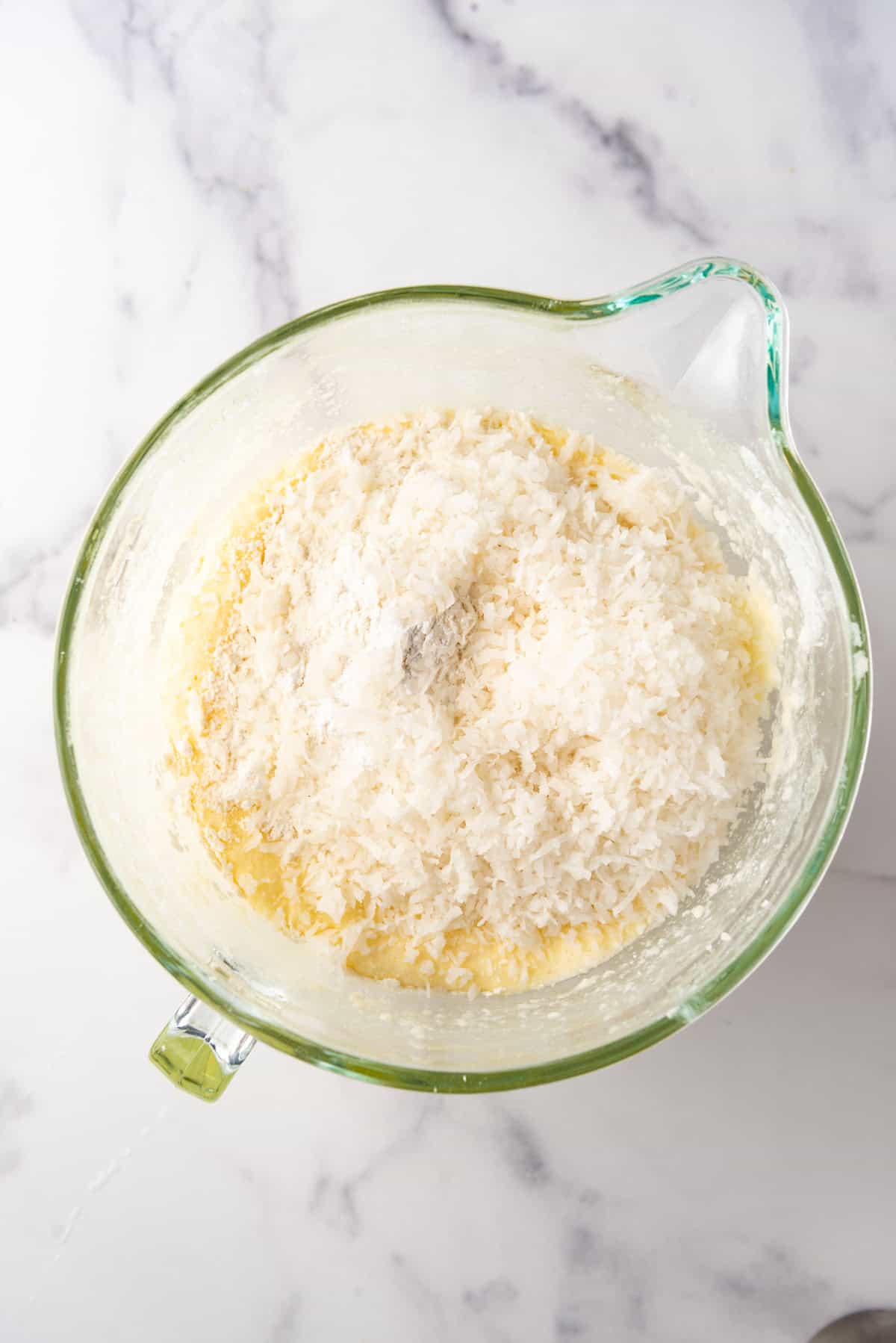 Adding shredded coconut to coconut bundt cake batter.