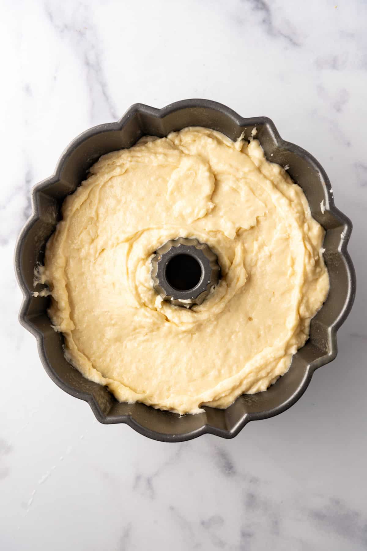 Coconut bundt cake batter in a bundt pan.