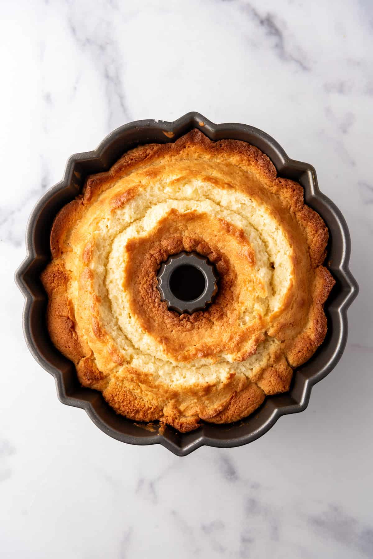 A baked coconut bundt cake cooling in the pan.