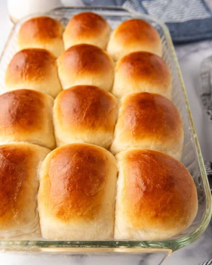 A side view of soft dinner rolls in a glass dish.