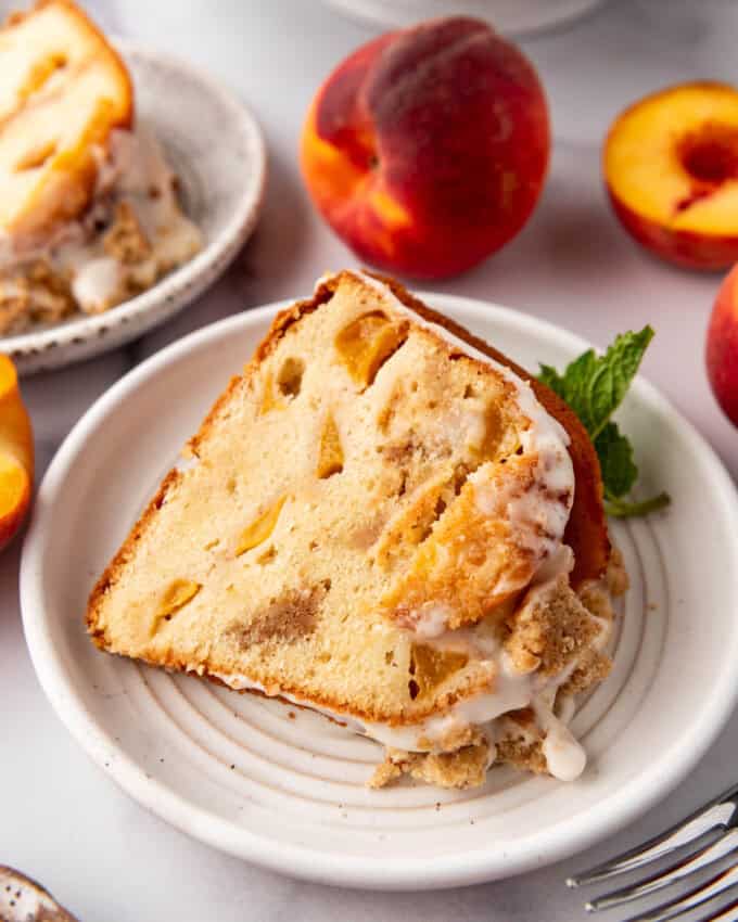 A slice of peach cobbler pound cake on a white plate.