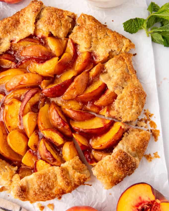 A sliced peach galette with one piece being pulled away from the others.