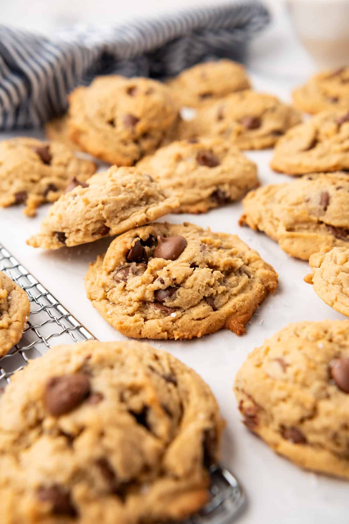 Peanut butter oatmeal cookies with milk chocolate chip cookies in front of a striped cloth napkin.