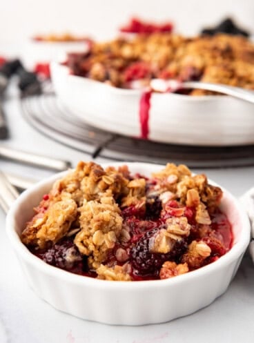 An image of mixed berry crisp in a white ramekin.