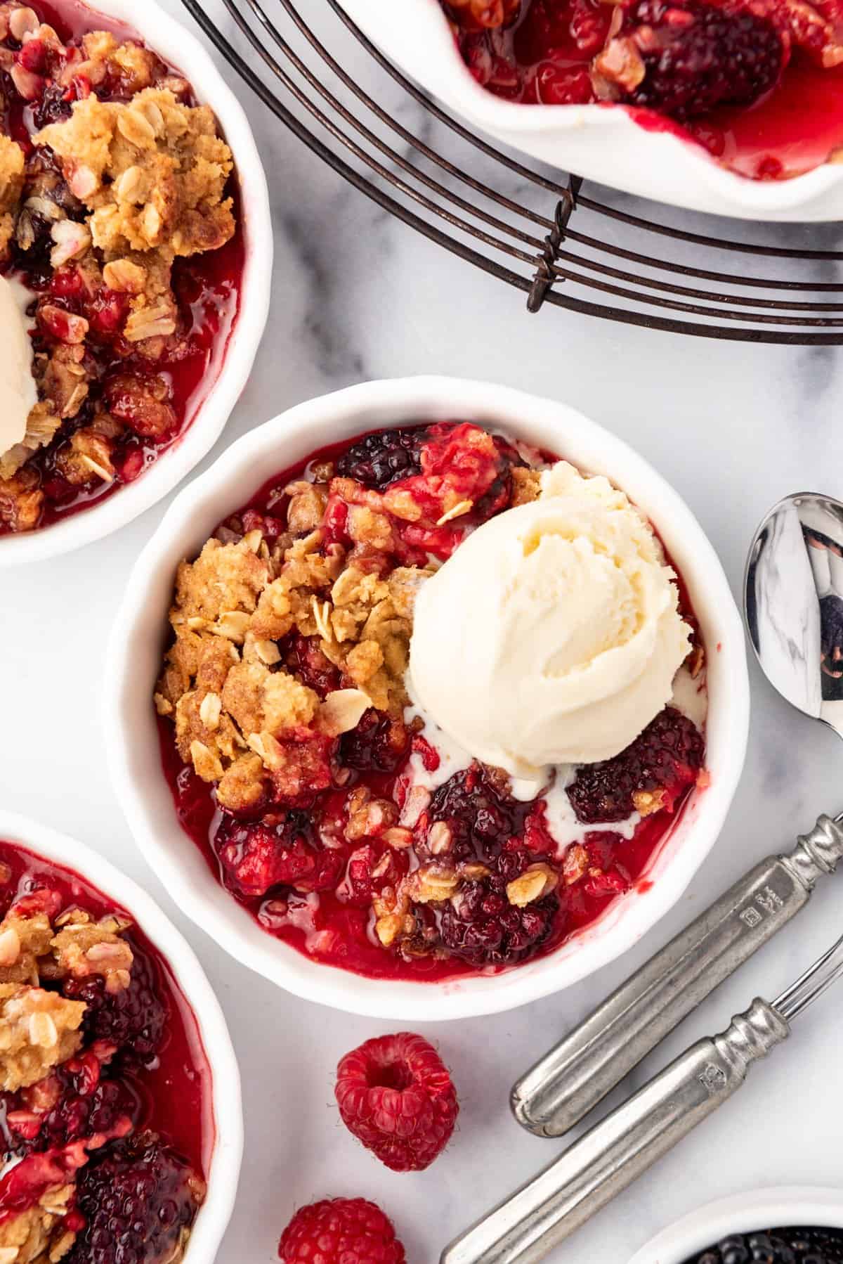 An overhead image of a bowl of berry crisp with ice cream.