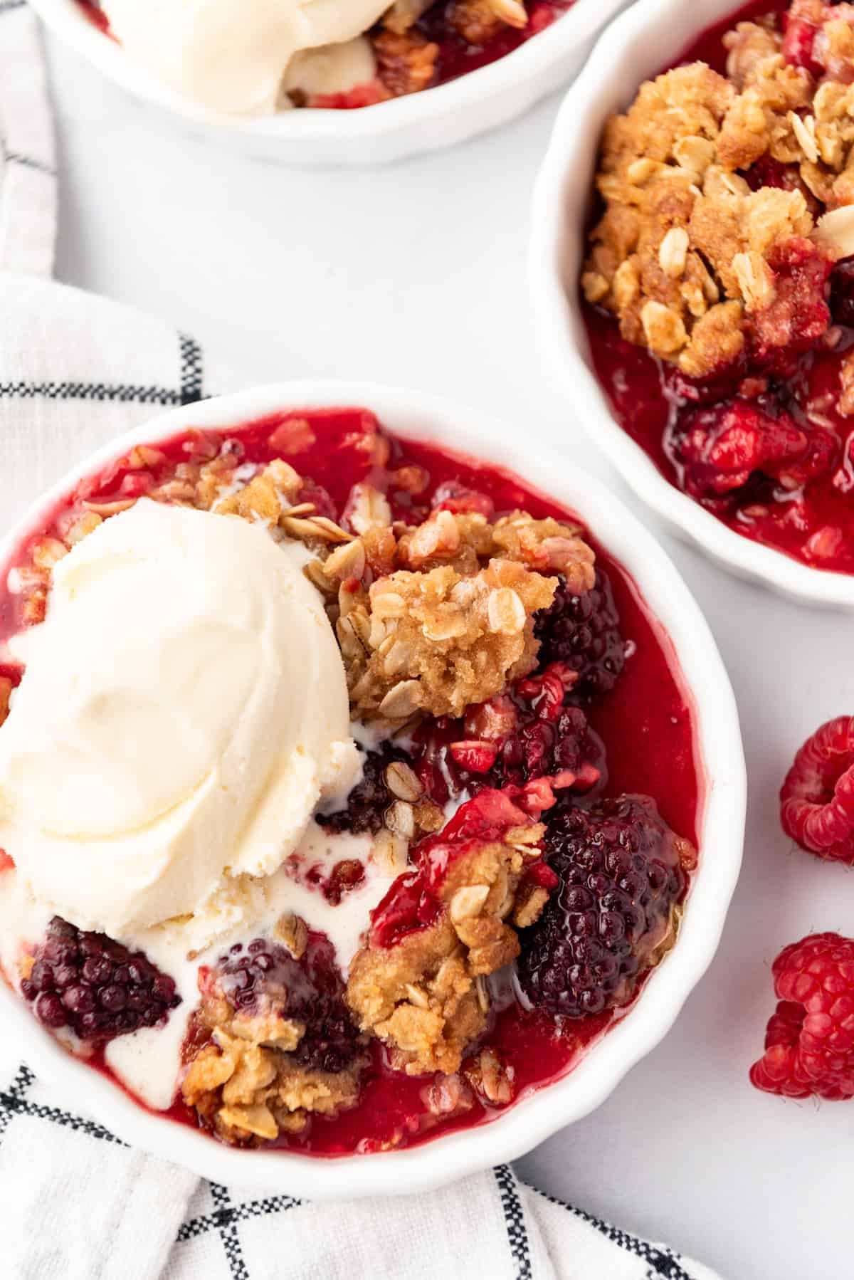 An overhead image of a bowl of berry crisp with ice cream.