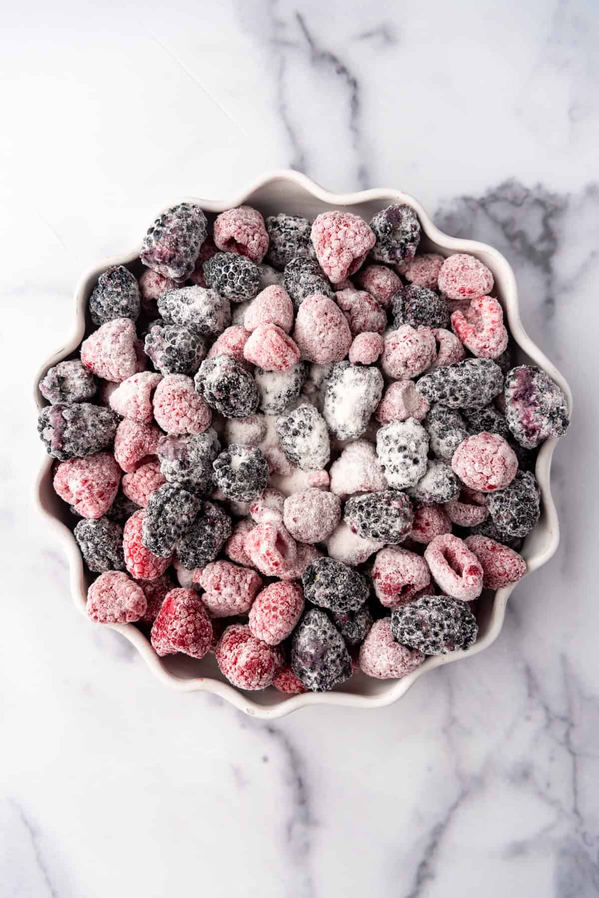 Berry crisp filling in a white baking dish.