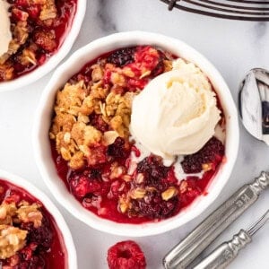 An overhead image of a bowl of berry crisp with ice cream.