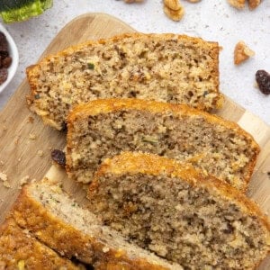 An overhead image of sliced pineapple zucchini bread on a wooden cutting board.