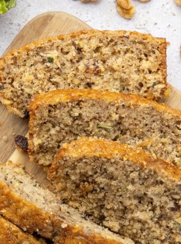 An overhead image of sliced pineapple zucchini bread on a wooden cutting board.