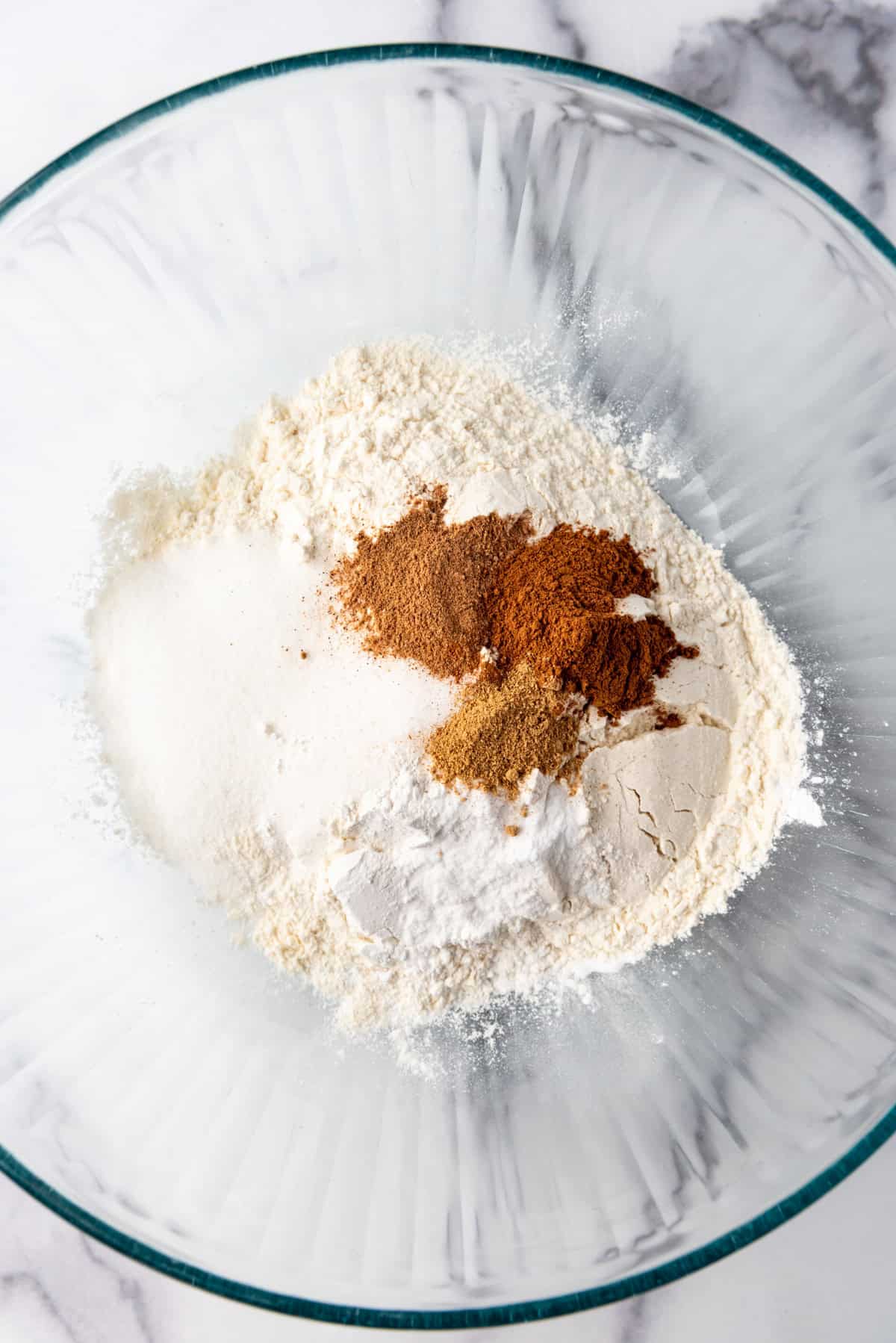 Flour, sugar, baking powder, and spices in a bowl.