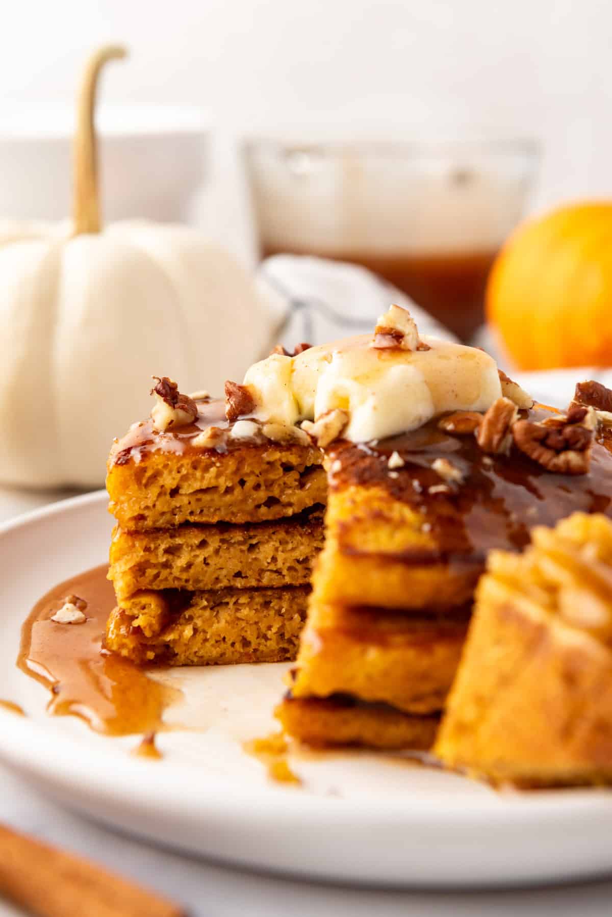 A stack of pumpkin pancakes with a bite taken out of them.