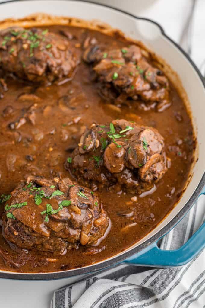 A side angle of salisbury steaks in a mushroom sauce.