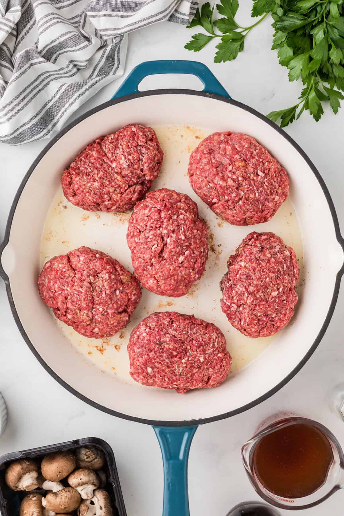 Searing salisbury steaks in a pan.