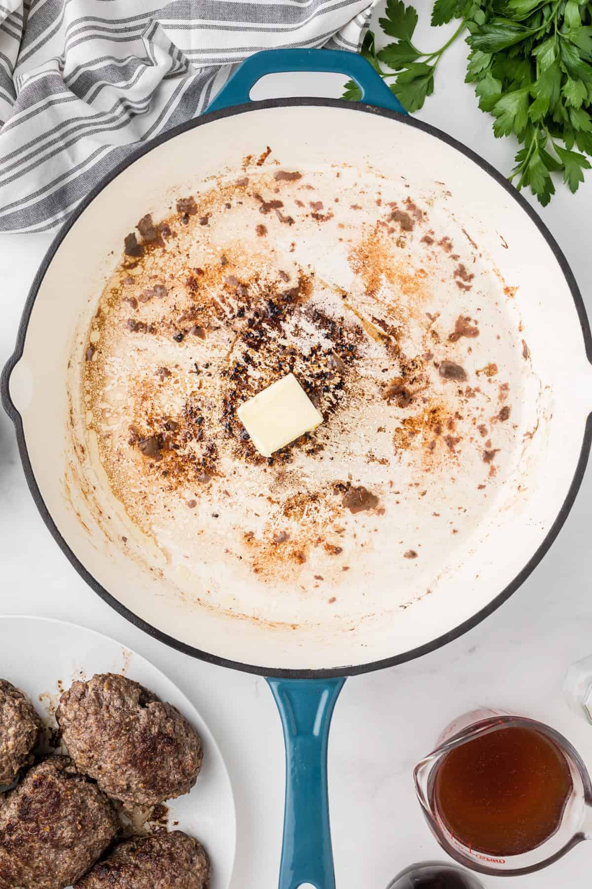 Adding butter to browned bits in the bottom of a pan.