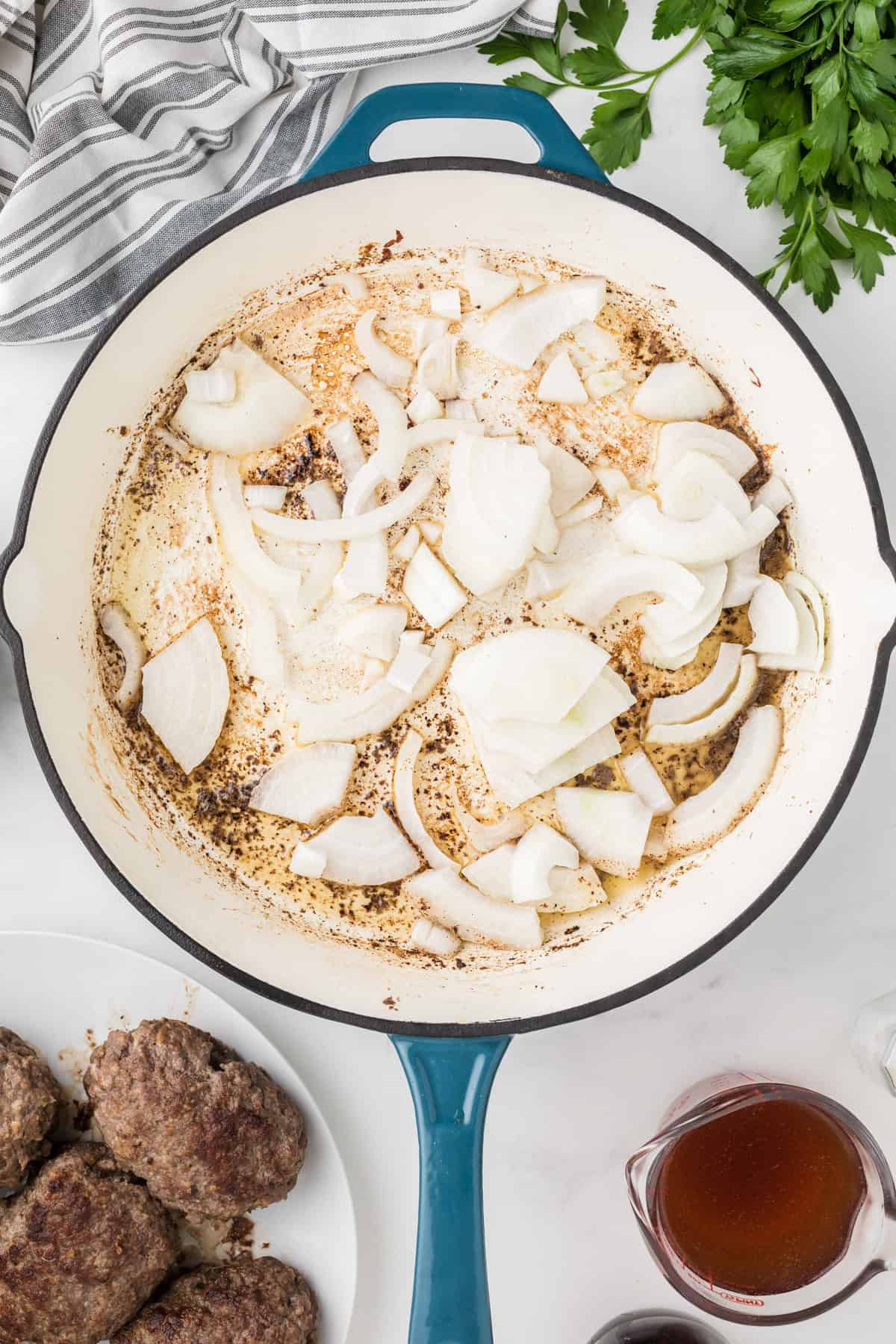 Adding sliced onions to a pan.