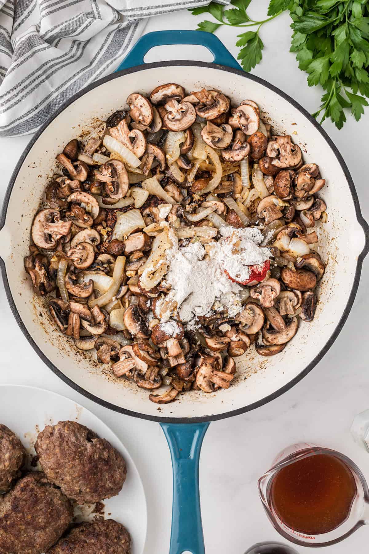 Adding flour and tomato paste to sauteed onions and mushrooms.