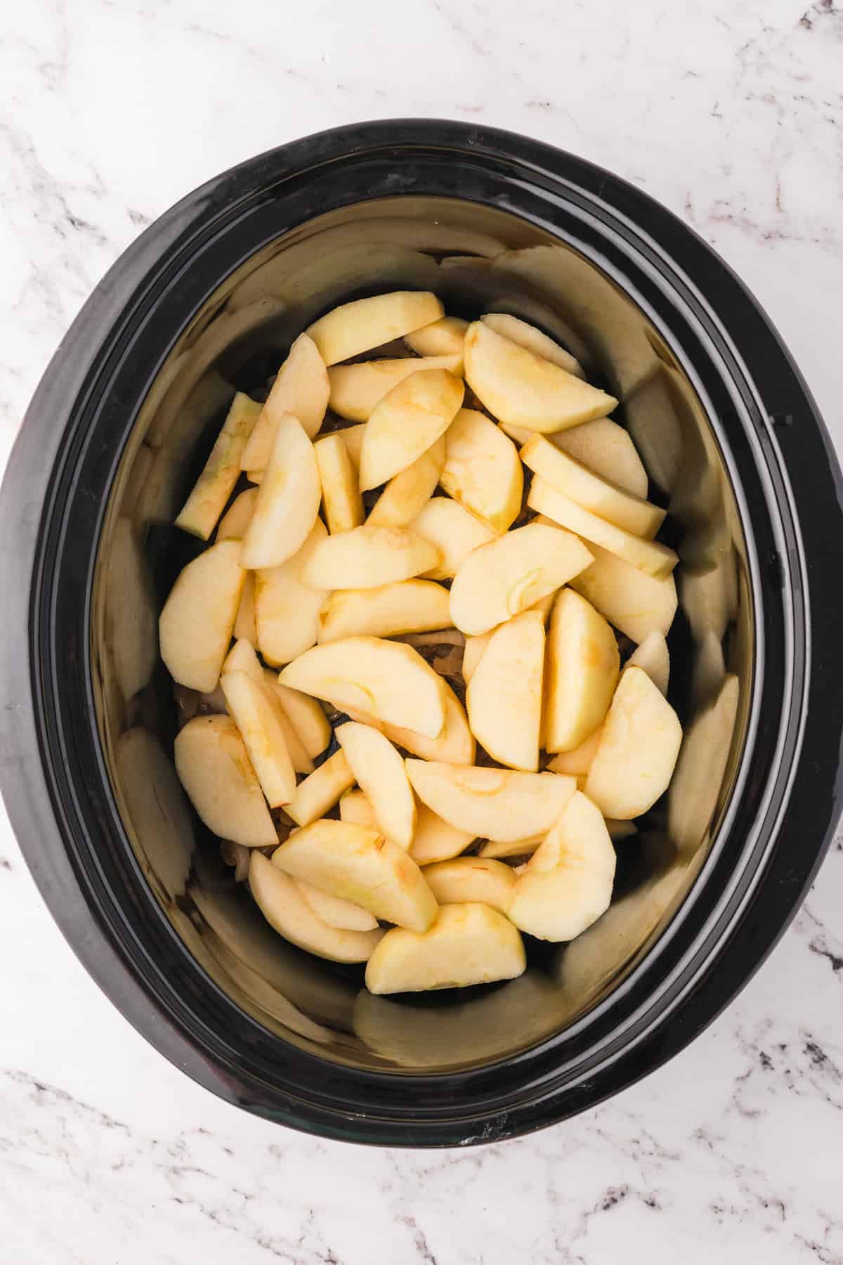 Sliced apples in a crock pot.