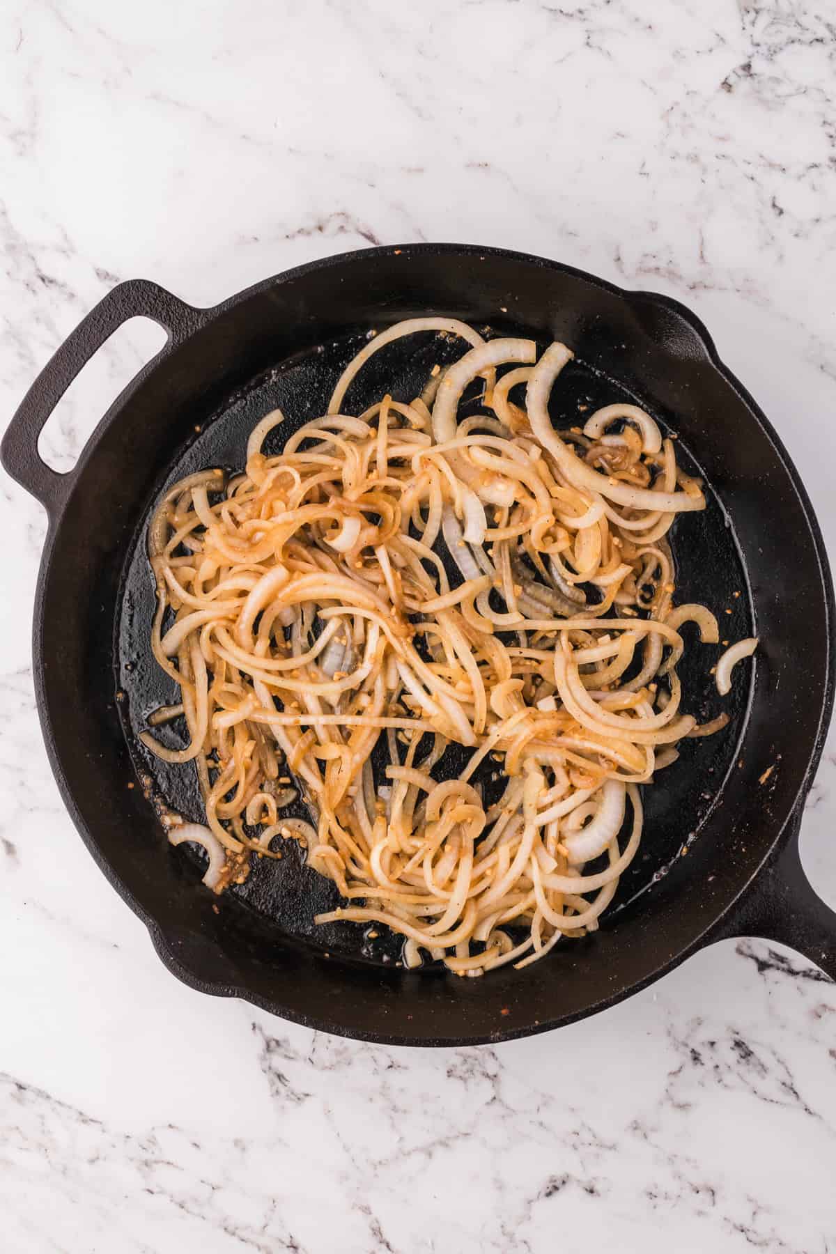 Sauteing sliced onions in a cast iron skillet.