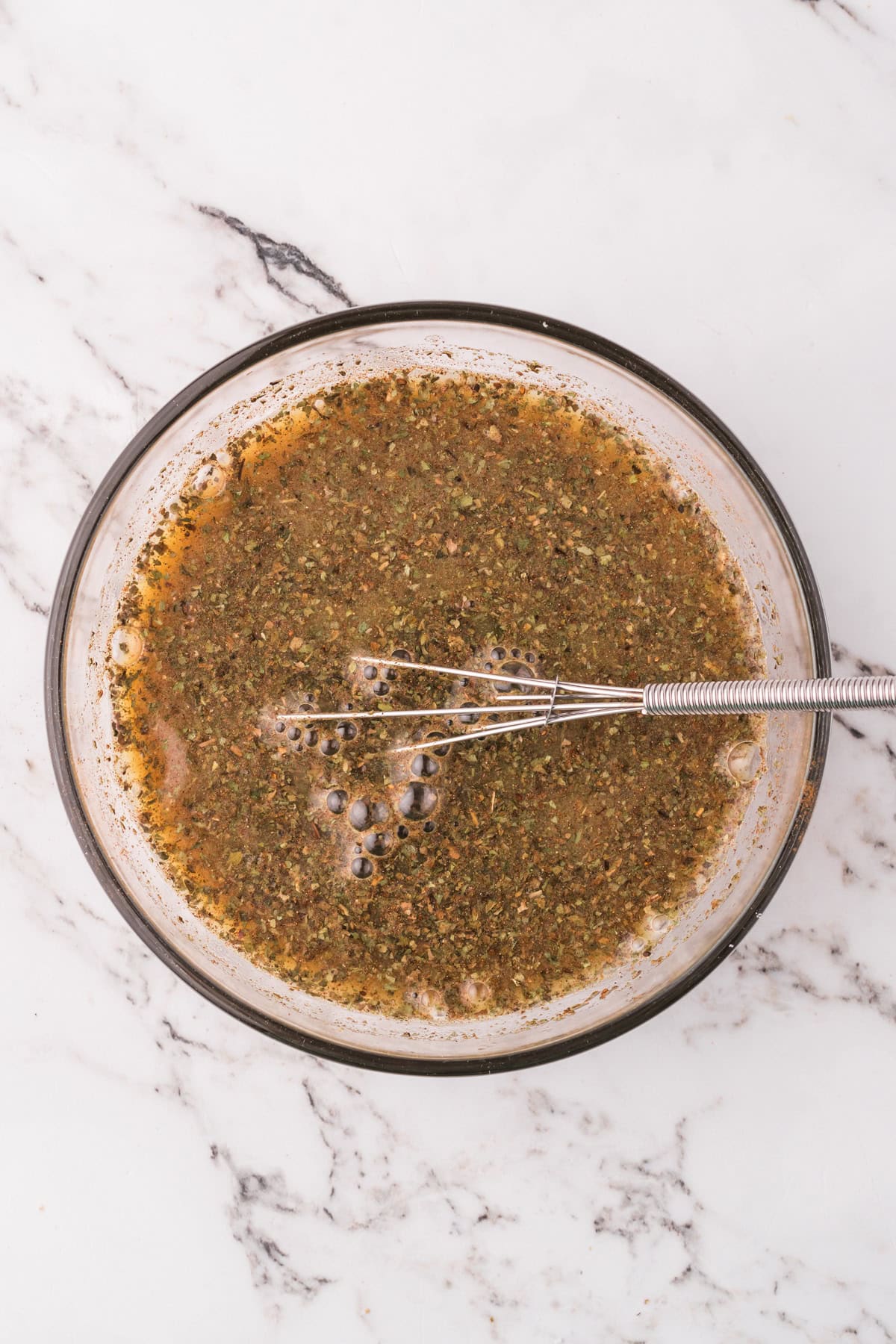 Whisking sauce ingredients together in a bowl.