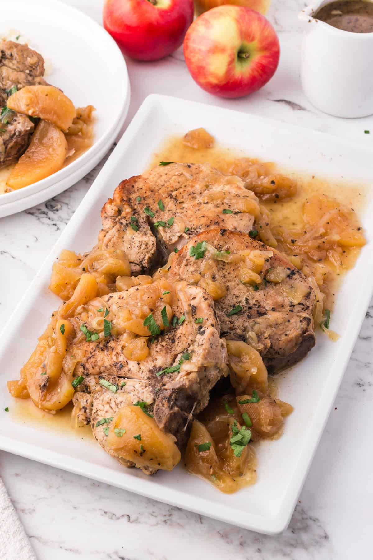 Slow cooker apple pork chops on a white serving platter.