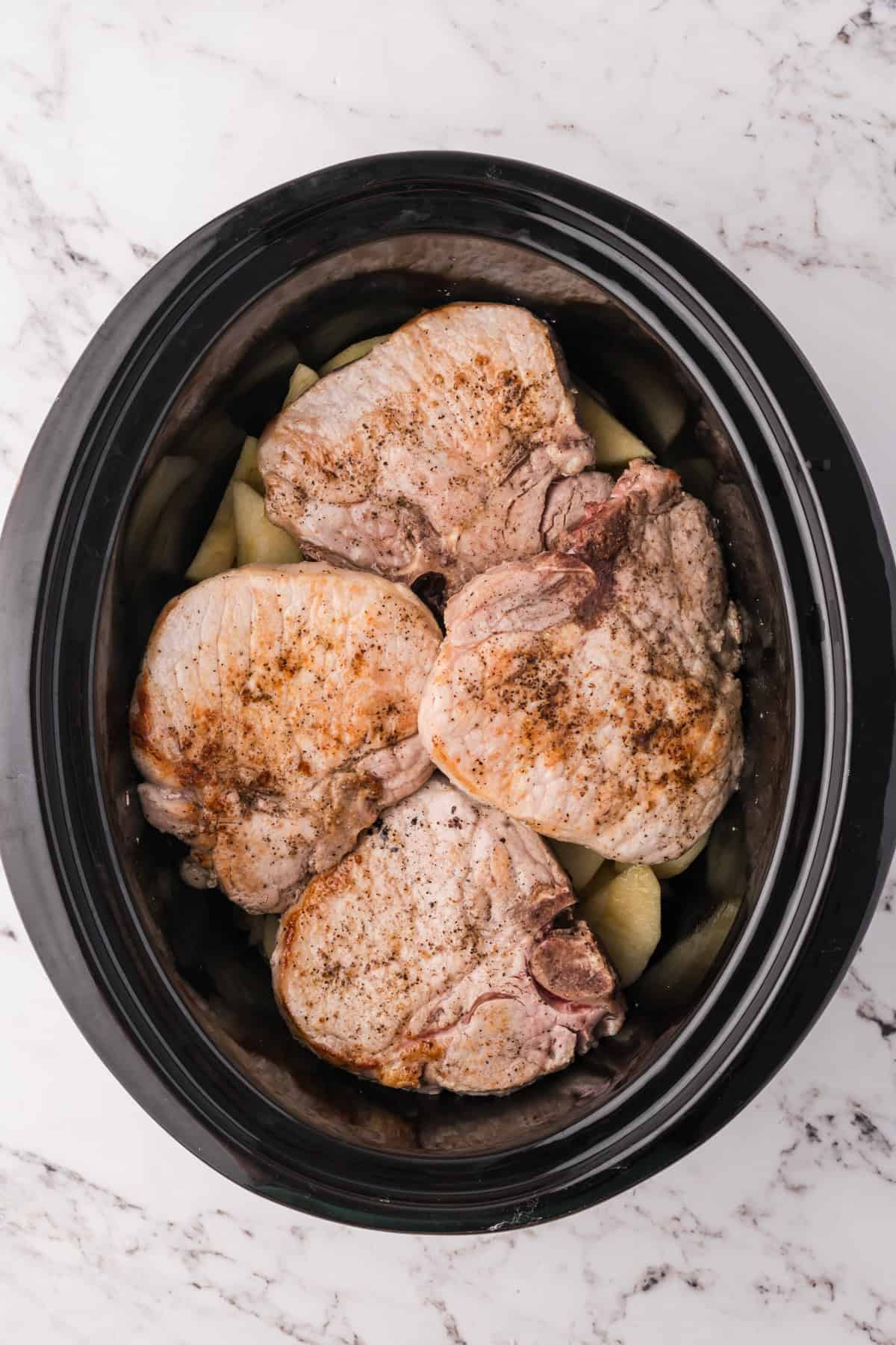 Four large pork chops in a crock pot.