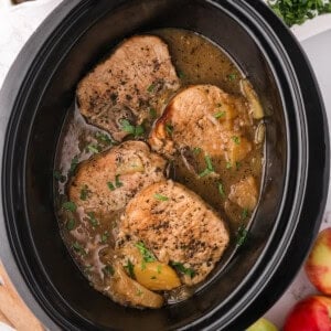 An image of slow cooker apple pork chops in the slow cooker.