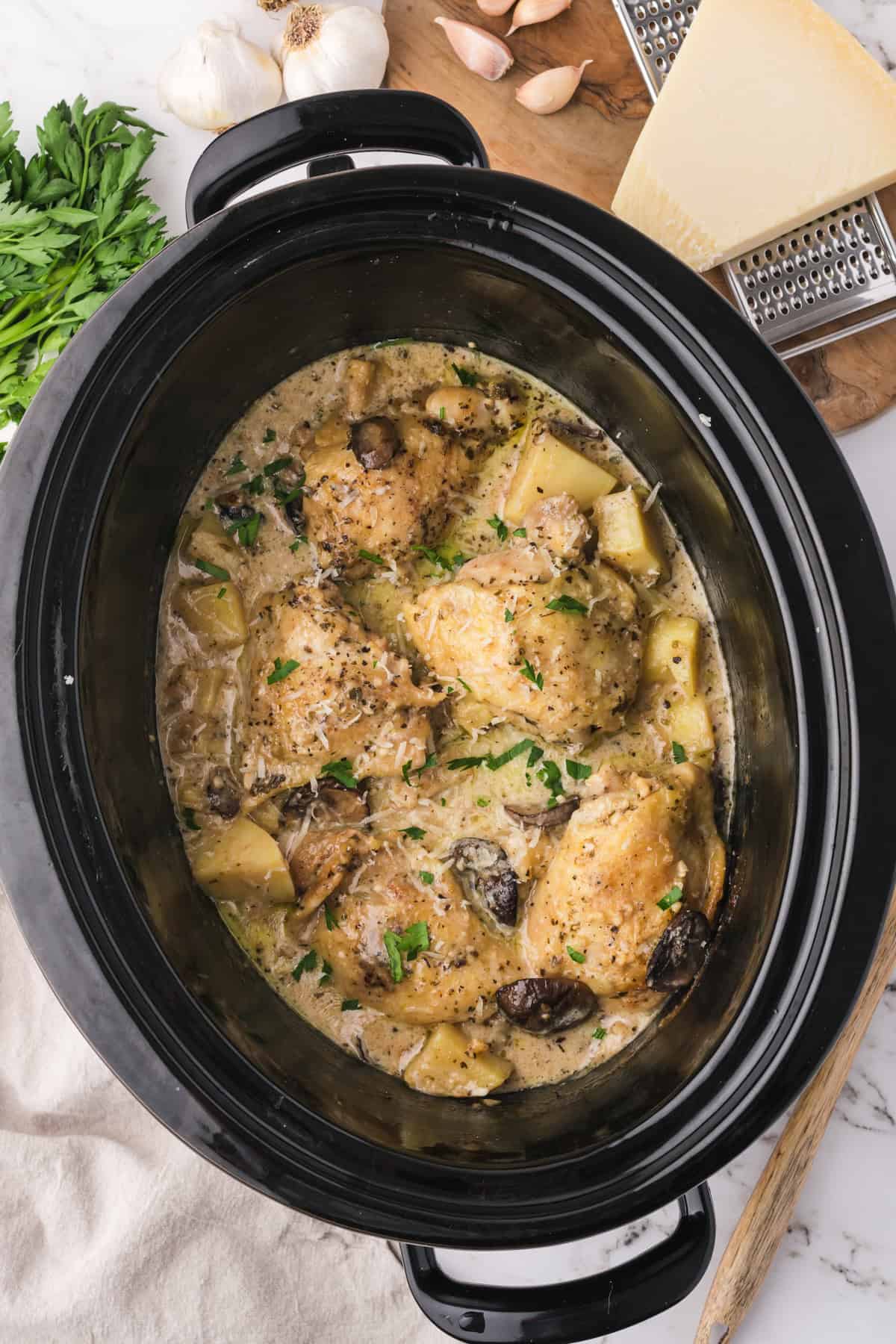 An overhead image of slow cooker garlic parmesan chicken in the slow cooker.