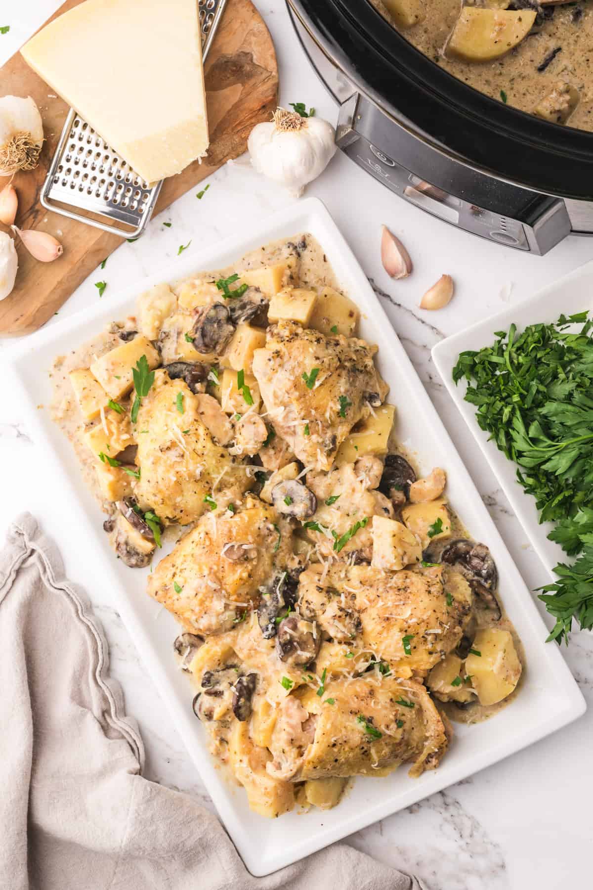 An overhead image of slow cooker garlic parmesan chicken thighs on a serving platter.