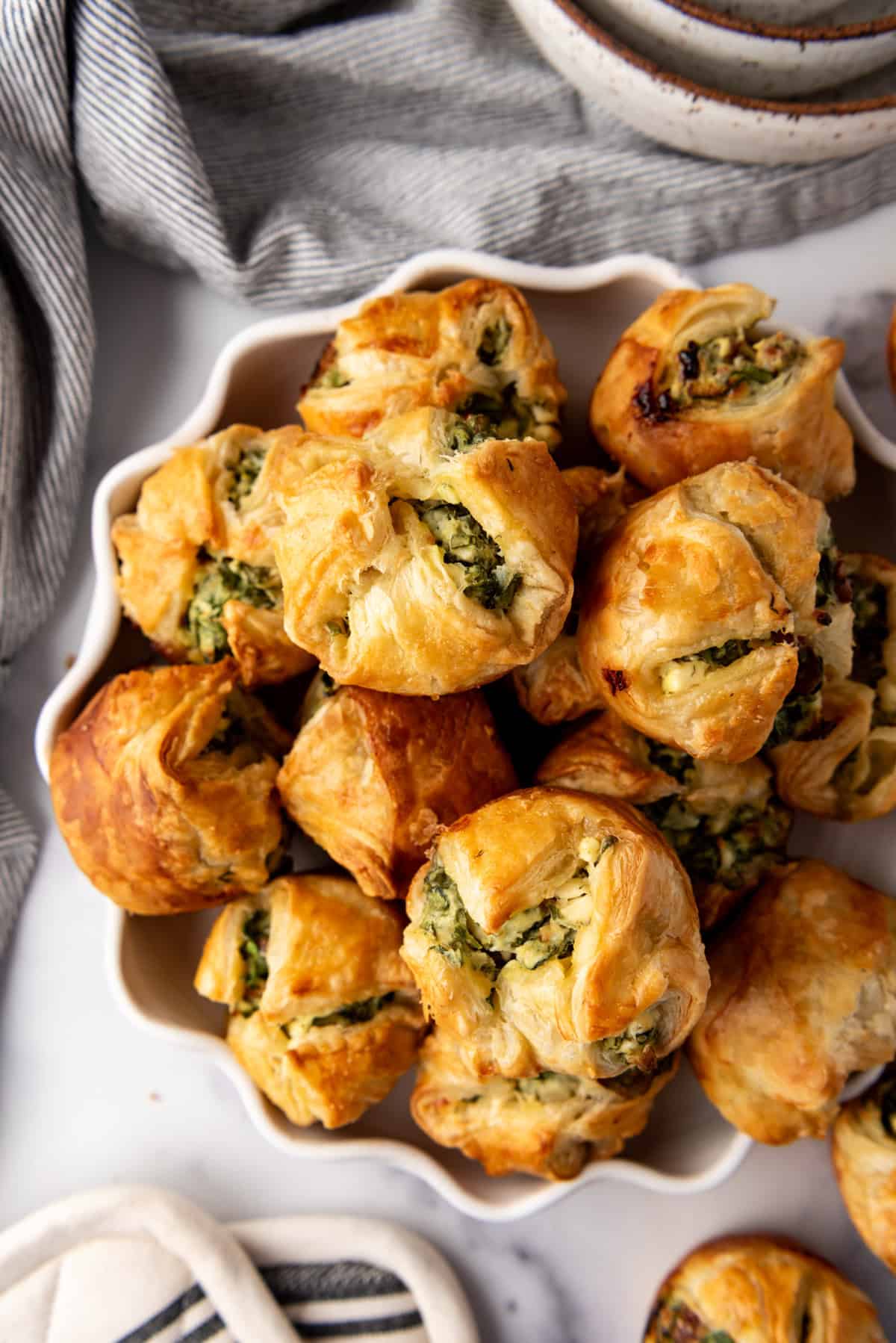 An overhead image of a bowl of spinach puffs.