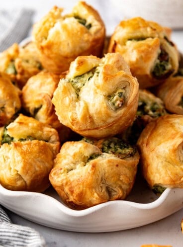 An image of spinach puffs piled in a bowl.