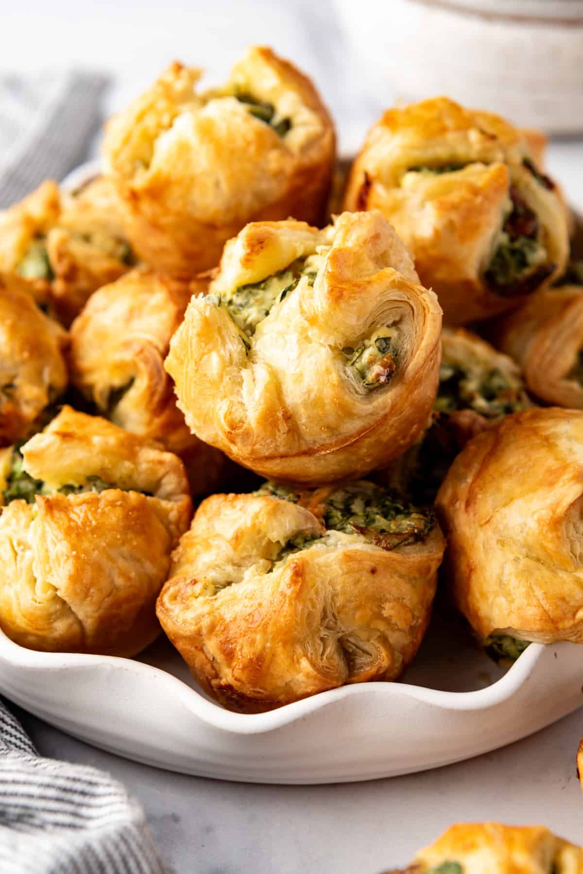 An image of spinach puffs piled in a bowl.