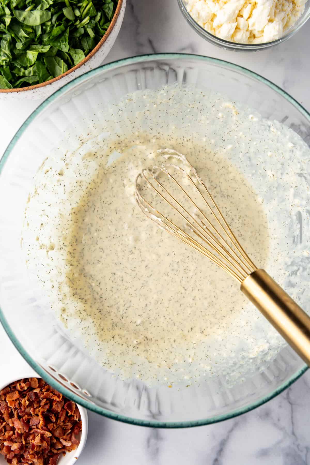 Whisked ingredients for spinach puffs filling.