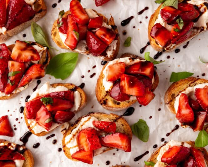 An overhead image of strawberry bruschetta drizzled with balsamic glaze.