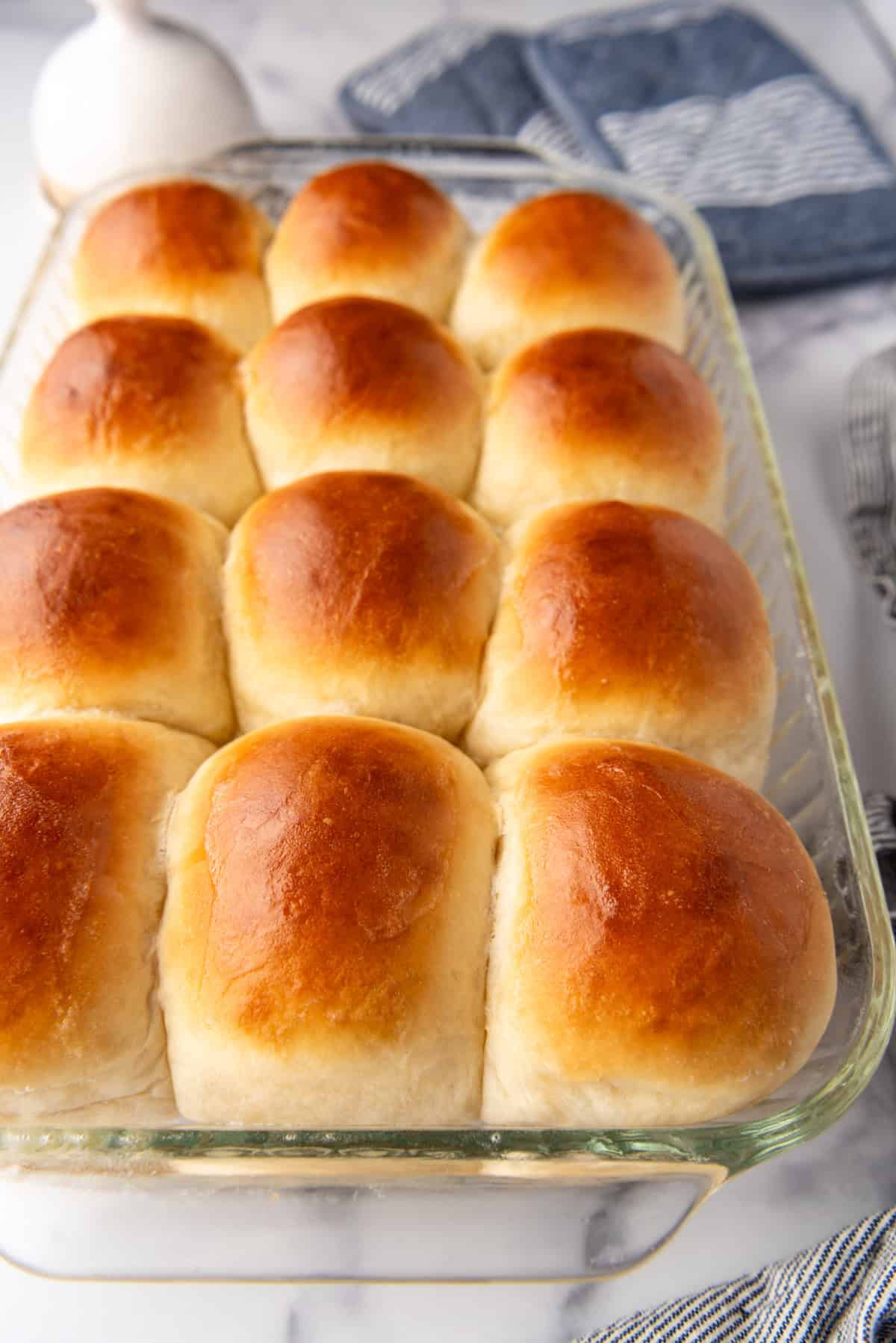 A side view of soft dinner rolls in a glass dish.